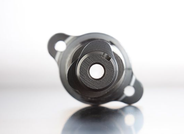 Metal mechanical component on a reflective surface with a white background