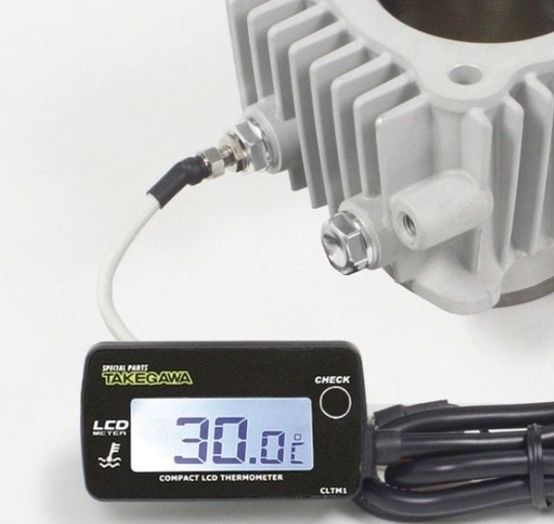 Takegawa compact LCD thermometer attached to a mechanical device on a white background