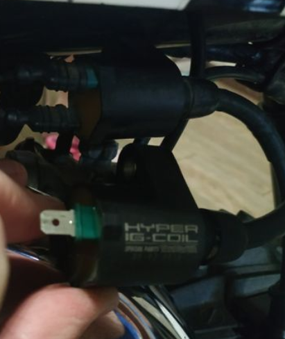 Close-up of a 'Hyper IIC Coil' electronic component held by a hand.