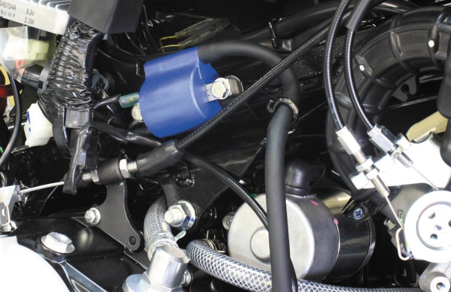 Close-up of a motorcycle engine with a blue ignition coil.