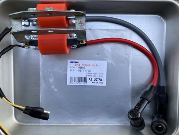 Electrical connector with red and black wires on a metal surface with a Utanit label.