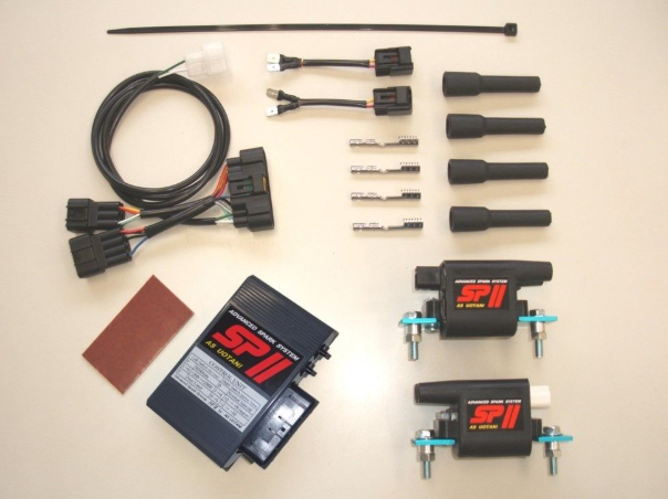 Automotive parts including wiring harnesses, connectors, and SP II branded components on a beige background.