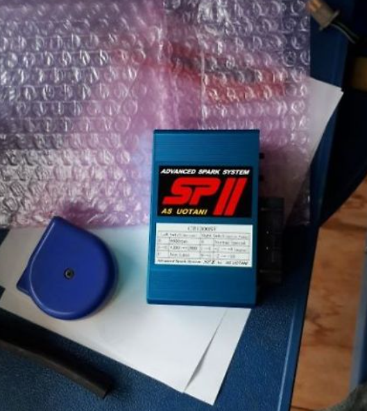 Blue box labeled 'SP II' on a textured surface with bubble wrap in the background