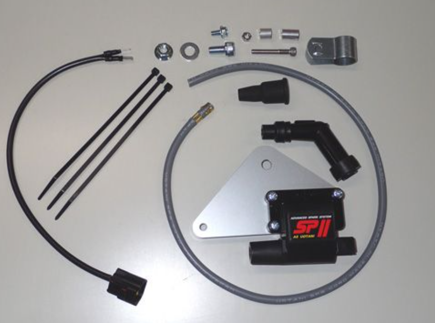 Collection of automotive parts including a metal plate with 'SP II' branding on a gray background