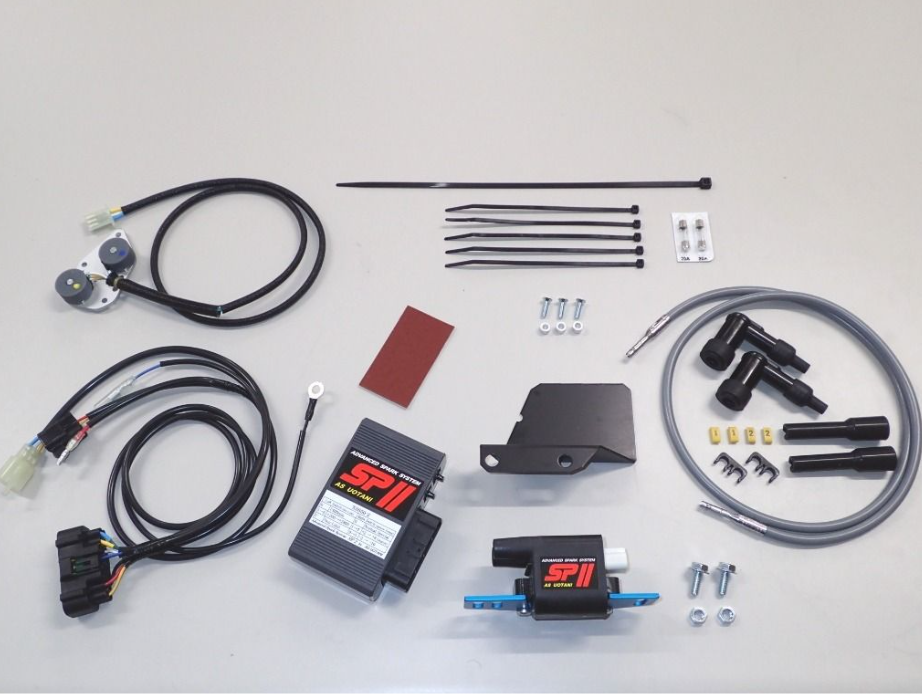 Automotive parts kit including wires, connectors, and metal components on a gray background