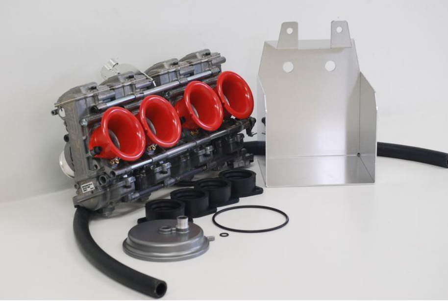 Car engine block with red intake manifold and metal box on a white background