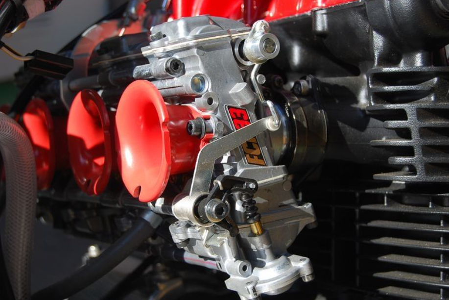 Close-up of a mechanical engine component with red parts and visible branding.