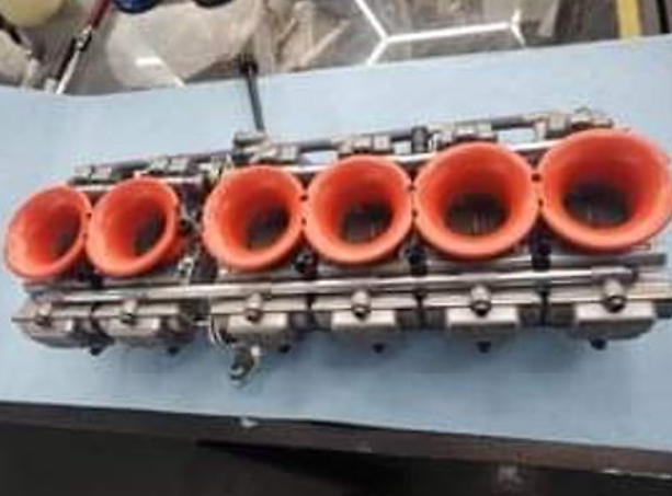 Engine block with orange cylinders on a blue surface