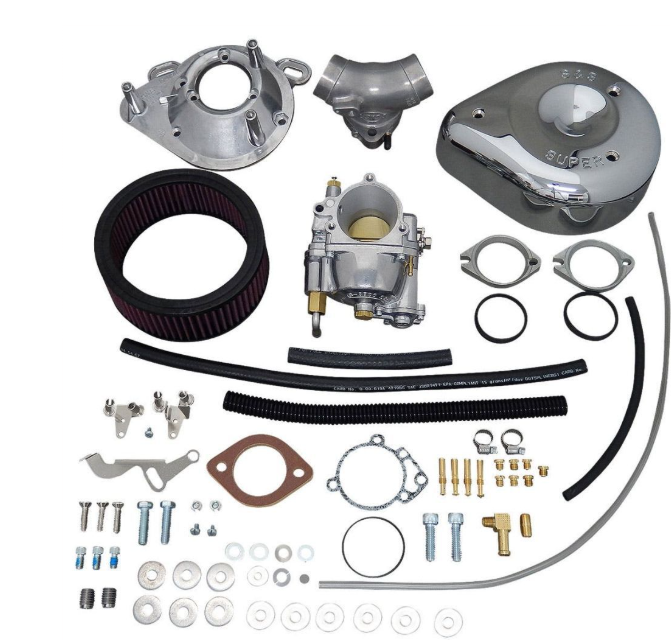 Collection of automotive parts including a carburetor, air filter, and various connectors on a white background.
