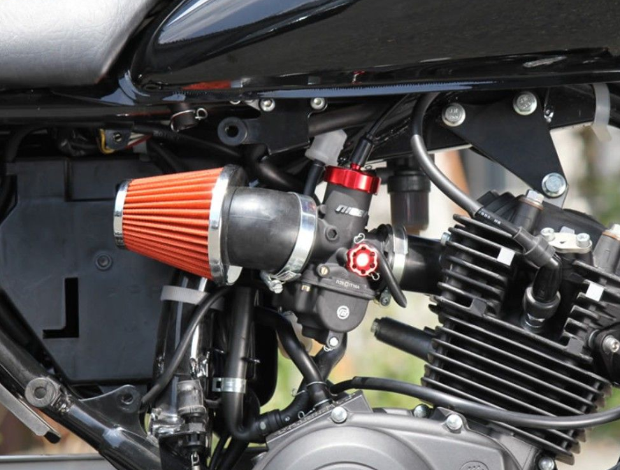 Close-up of a motorcycle engine with an orange air filter