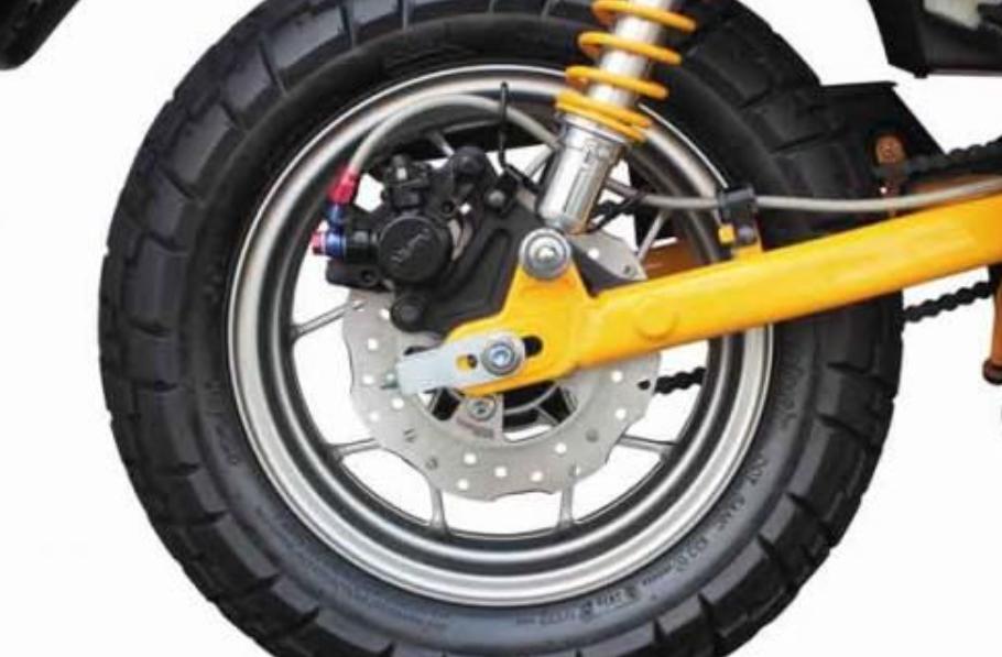 Close-up of a motorcycle wheel with suspension and brake components on a white background