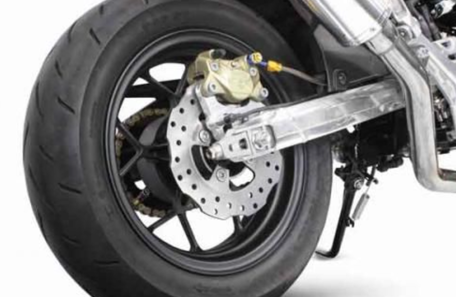 Close-up of a motorcycle wheel with disc brake on a white background
