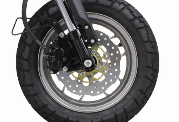 Close-up of a motorcycle wheel with tire and suspension on a white background