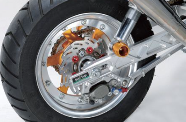 Close-up of a motorcycle wheel with visible mechanical components on a white background