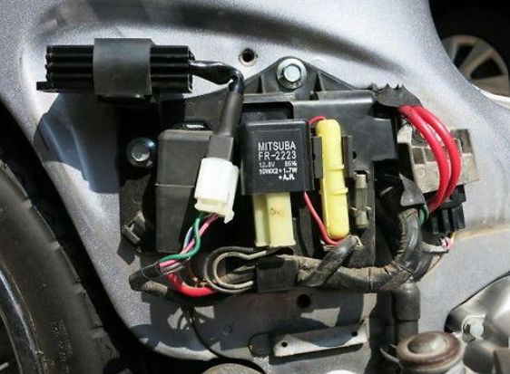 Close-up of a car's electrical connector with Mitsubishi branding.