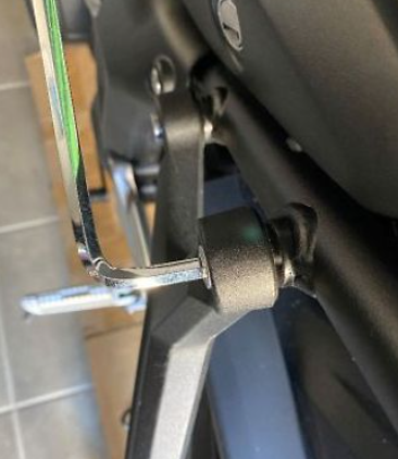 Close-up of a metal lever on a piece of equipment, possibly a chair or vehicle component.