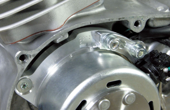Close-up of a metallic engine component with bolts and metal parts.