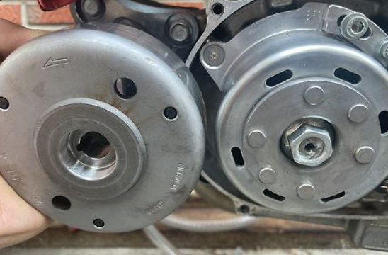 Close-up of two metal pulleys held by a hand against a blurred background