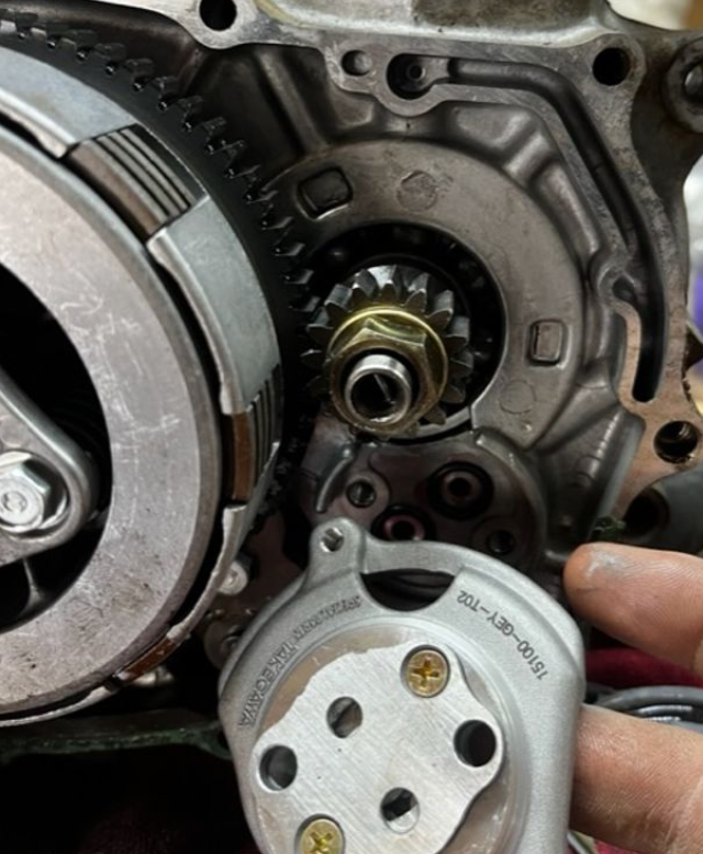 Close-up of mechanical components with a hand holding one part.