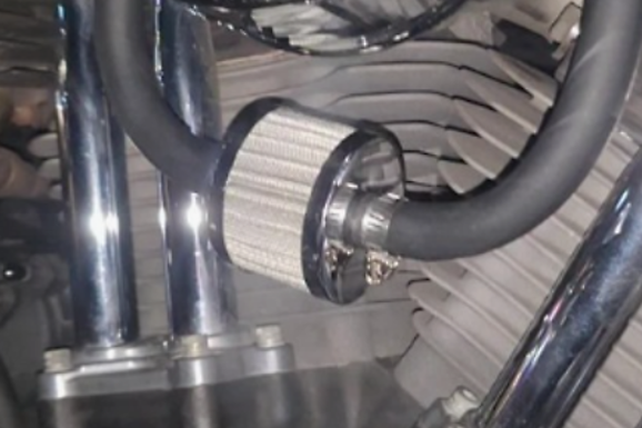 Close-up of a motorcycle engine with chrome parts and air filter.